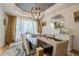 Formal dining room featuring a dark wood table, neutral chairs, stylish chandelier, and bright natural light at 4096 Vinings Mill Se Trl, Smyrna, GA 30080