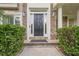 Front door with stone facade and sidelights flanked by manicured bushes for added curb appeal at 4096 Vinings Mill Se Trl, Smyrna, GA 30080