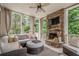 Cozy sunroom featuring a stone fireplace, comfortable seating, and serene views of the surrounding greenery at 4096 Vinings Mill Se Trl, Smyrna, GA 30080