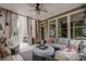 Inviting sunroom with plush sofa, wicker furniture, and multiple windows offering views of the lush outdoors at 4096 Vinings Mill Se Trl, Smyrna, GA 30080