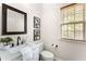A cozy powder room features a decorative mirror, granite countertop and plenty of natural light at 5828 Paliser Trce, Sugar Hill, GA 30518