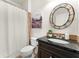 This updated bathroom includes a decorative mirror, granite countertop and a decorative tile accent wall at 5828 Paliser Trce, Sugar Hill, GA 30518