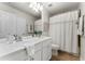This bathroom features a single vanity, large mirror, and a shower-tub combination with a decorative curtain at 5828 Paliser Trce, Sugar Hill, GA 30518