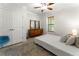Bedroom with natural light from windows, complemented by a vintage dresser and neutral-toned bedding and decor at 5828 Paliser Trce, Sugar Hill, GA 30518