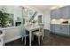 A brightly lit dining area featuring hardwood floors, a dining table with seating, and view into living room at 5828 Paliser Trce, Sugar Hill, GA 30518