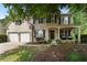 Charming two-story brick home with a covered front porch, two-car garage, and well-manicured lawn at 5828 Paliser Trce, Sugar Hill, GA 30518