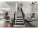 An elegant foyer featuring a staircase, hardwood floors, and an open view to the dining and living areas at 5828 Paliser Trce, Sugar Hill, GA 30518
