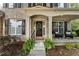 Inviting front porch with seating, decorative wreath on door, and lush landscaping creating a welcoming entrance at 5828 Paliser Trce, Sugar Hill, GA 30518