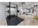 This home gym features a power rack with weights, and exercise machine, and rubber flooring to protect the floor at 5828 Paliser Trce, Sugar Hill, GA 30518