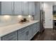 Kitchen with stainless steel refrigerator, modern gray cabinets, white countertop, and wood flooring at 5828 Paliser Trce, Sugar Hill, GA 30518