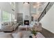 A bright living room with soaring ceilings, a fireplace, and large windows at 5828 Paliser Trce, Sugar Hill, GA 30518