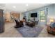 Bright living room featuring a rocking chair, large area rug, built in bookshelves and a large wall-mounted television at 5828 Paliser Trce, Sugar Hill, GA 30518