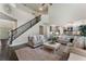 Open-concept living room with staircase view that leads to a modern kitchen with gray cabinets and stainless appliances at 5828 Paliser Trce, Sugar Hill, GA 30518