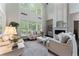 Bright living room with soaring ceilings, large windows, fireplace, and neutral decor exudes warmth and elegance at 5828 Paliser Trce, Sugar Hill, GA 30518