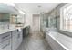 Beautifully renovated bathroom with double sinks, soaking tub and custom window for a relaxing spa-like experience at 5828 Paliser Trce, Sugar Hill, GA 30518