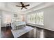 A bright primary bedroom with a decorative tray ceiling, dark hardwood floors, and three windows at 5828 Paliser Trce, Sugar Hill, GA 30518
