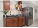 This wet bar features attractive wood cabinetry, countertop lighting, a stainless steel sink and a full size refrigerator at 5828 Paliser Trce, Sugar Hill, GA 30518