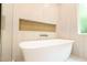 Close-up of a luxurious soaking tub with modern fixtures and a built-in alcove at 219 Poplar Nw St, Lilburn, GA 30047