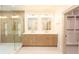Stylish bathroom with a double sink vanity, glass shower, and access to a walk-in closet at 219 Poplar Nw St, Lilburn, GA 30047