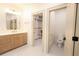 Bright bathroom featuring a modern vanity, elegant mirror, and doorways to the toilet and closet at 219 Poplar Nw St, Lilburn, GA 30047
