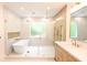 Luxury bathroom showcasing a soaking tub and glass enclosed shower with a wooden vanity at 219 Poplar Nw St, Lilburn, GA 30047