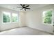 Bright bedroom features a ceiling fan and multiple windows for ample natural light at 219 Poplar Nw St, Lilburn, GA 30047