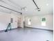 Open garage space with epoxy floors, white walls, natural light, and an access door enhance utility at 219 Poplar Nw St, Lilburn, GA 30047