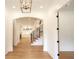 Bright hallway with hardwood floors, modern railing, and an arched doorway leading to other rooms at 219 Poplar Nw St, Lilburn, GA 30047