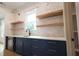 Stylish pantry featuring blue cabinetry, floating shelves, and a functional wet bar area at 219 Poplar Nw St, Lilburn, GA 30047