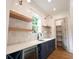 A functional pantry featuring a wet bar, floating shelves, blue cabinets, and sleek countertops at 219 Poplar Nw St, Lilburn, GA 30047