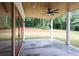Covered back patio with wood ceiling, ceiling fan, and large glass doors providing easy access to backyard at 219 Poplar Nw St, Lilburn, GA 30047