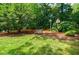 Spacious backyard with bench, birdhouses, mature trees and landscaped lawn at 3030 Spalding Dr, Sandy Springs, GA 30350