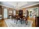 A formal dining room is adorned with an elegant chandelier, hardwood floors, and classic decor at 3030 Spalding Dr, Sandy Springs, GA 30350
