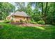 Well-manicured lawn, mature trees, and brick home with great curb appeal surrounded by beautiful landscaping at 3030 Spalding Dr, Sandy Springs, GA 30350