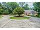 Charming brick home featuring circular driveway and lush landscaping at 3030 Spalding Dr, Sandy Springs, GA 30350