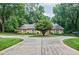 Charming brick home with a circular driveway and mature trees around the well-manicured lawn at 3030 Spalding Dr, Sandy Springs, GA 30350
