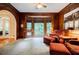 Living room featuring wood paneling, plush seating, bay window, and carpet flooring at 3030 Spalding Dr, Sandy Springs, GA 30350