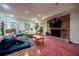 Large basement living room featuring a brick fireplace, bookshelves, and comfortable seating area at 3030 Spalding Dr, Sandy Springs, GA 30350