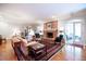 Bright living room with a brick fireplace, hardwood floors, and arched doorways to other rooms at 3030 Spalding Dr, Sandy Springs, GA 30350