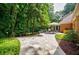 Outdoor patio with stone pavers, a dining table, and lush greenery creating a serene backyard retreat at 3030 Spalding Dr, Sandy Springs, GA 30350