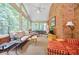Relaxing sunroom with many windows, ceiling fan, and exposed brick wall at 3030 Spalding Dr, Sandy Springs, GA 30350