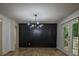 Dining room with black accent wall, modern light fixture and hardwood floors at 5640 Redan Cir, Stone Mountain, GA 30088