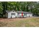 Newly renovated home with a well-manicured front yard and a bright orange front door at 5640 Redan Cir, Stone Mountain, GA 30088