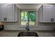 Bright kitchen with a stainless steel sink and a window view of lush greenery at 5640 Redan Cir, Stone Mountain, GA 30088