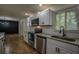 Open kitchen with stainless steel appliances, granite countertops, white cabinets and hardwood floors at 5640 Redan Cir, Stone Mountain, GA 30088