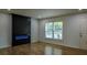 Cozy living room featuring stylish dark electric fireplace, bright natural light, and beautiful modern wood floors at 5640 Redan Cir, Stone Mountain, GA 30088