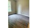 Bedroom featuring wood-look floors, a window, and neutral wall paint at 6103 Chaseland Dr, Rex, GA 30273