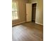 Bedroom featuring wood-look floors, closet, window, and painted walls at 6103 Chaseland Dr, Rex, GA 30273
