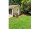 Side exterior of a tan home, featuring a side entry door and lush foliage at 6103 Chaseland Dr, Rex, GA 30273