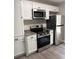 Updated kitchen with modern stainless steel appliances, including range and refrigerator, and white cabinets at 6103 Chaseland Dr, Rex, GA 30273